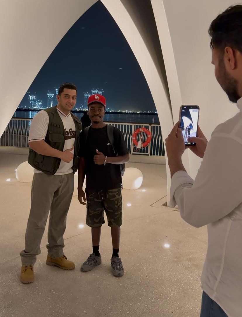 Chancio et son client posant le soir devant la baie de Dubaï